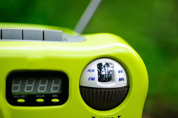 plastic radio, technology, AM FM radio, digital display, portable radio, green background, radio tuning, kHz MHz, outdoor radio, compact radio, electronic device